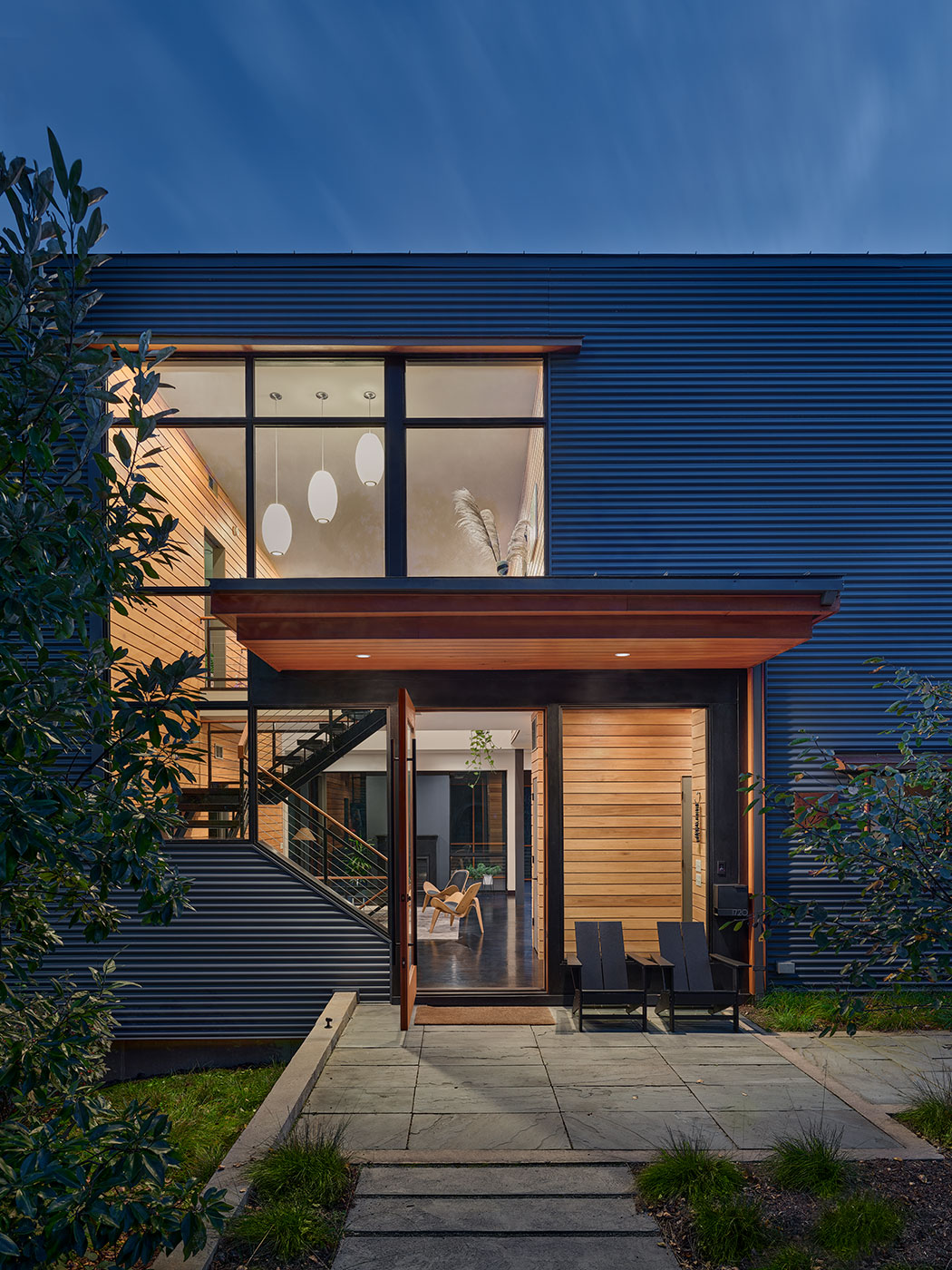 Night View Detail of Entrance with Corrugated Grey Siding, Cantilevered Wood Canopy in Charlottesville, VA by Chris Hays Modern Green Architect with HEDS.