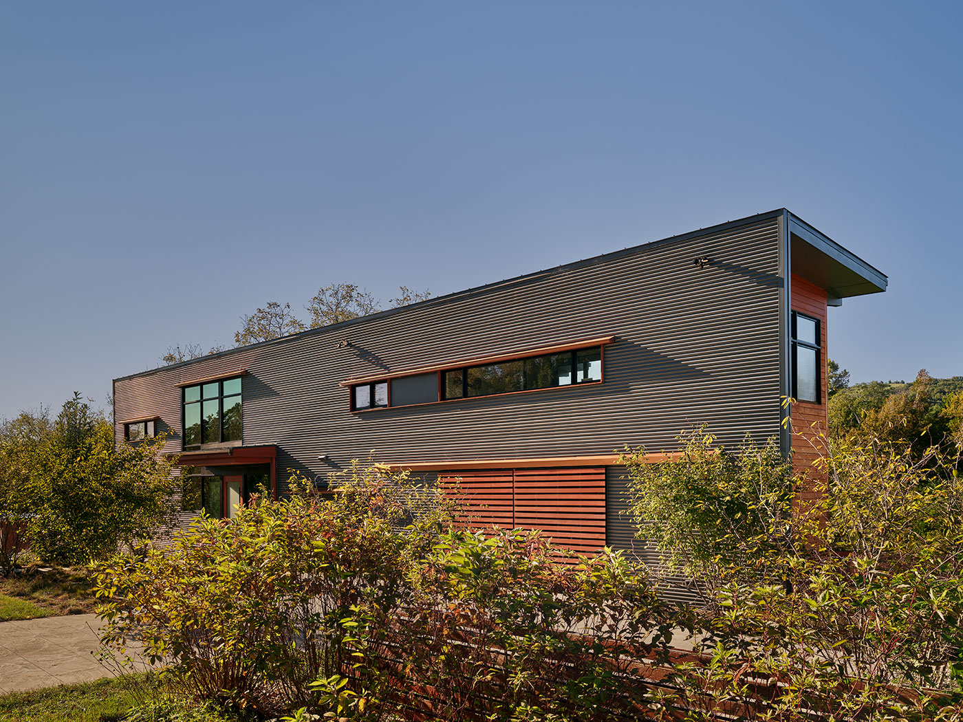 Corrugated Grey Siding with Sliding Garage Doors, Long Glass Windows, Cantilevered Wood Canopy in Charlottesville, VA by Chris Hays Modern Green Architect with HEDS.