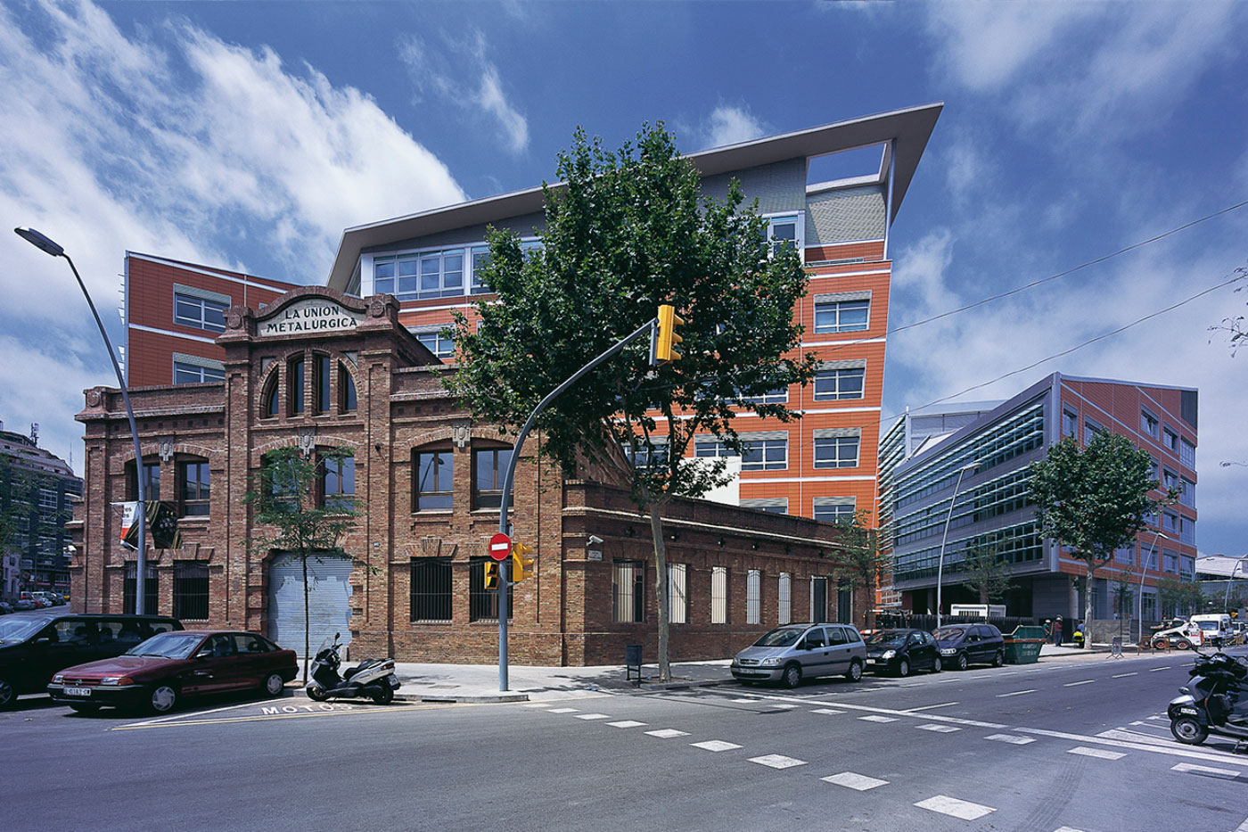 Eco-Urban 22 @ Barcelona Mixed-Use Project by Award-Winning Virginia-Based Architect Site Behind Existing Historic Structure and has Colorful Wall Cladding and Deep Overhangs.