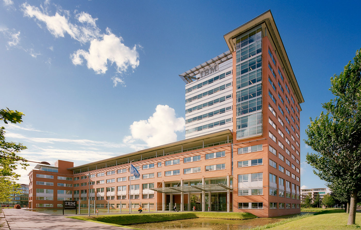 View of the IBM Headquarters in Hilversum, The Netherlandsis Surrounded by a Moat with Bermed Entrance, Glass Canopy and Tower in Foreground by Renowned Green Architect Located in Virginia.