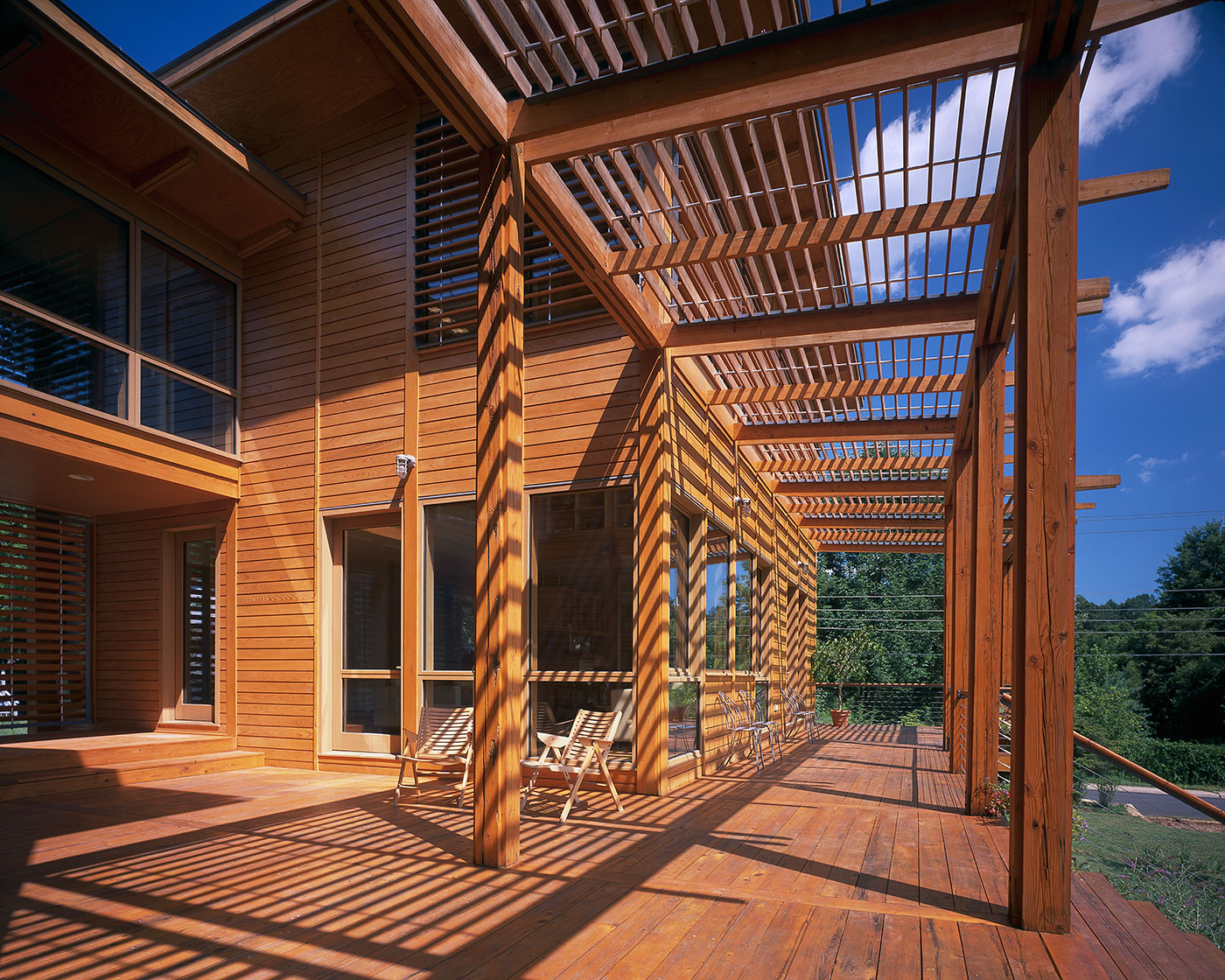 Image of Modern Green Charlottesville Home by HEDS Architects has Stained Wood Shiplap, Wood Trellis and wood deck where Shadow Streaks the Wall and Deck.