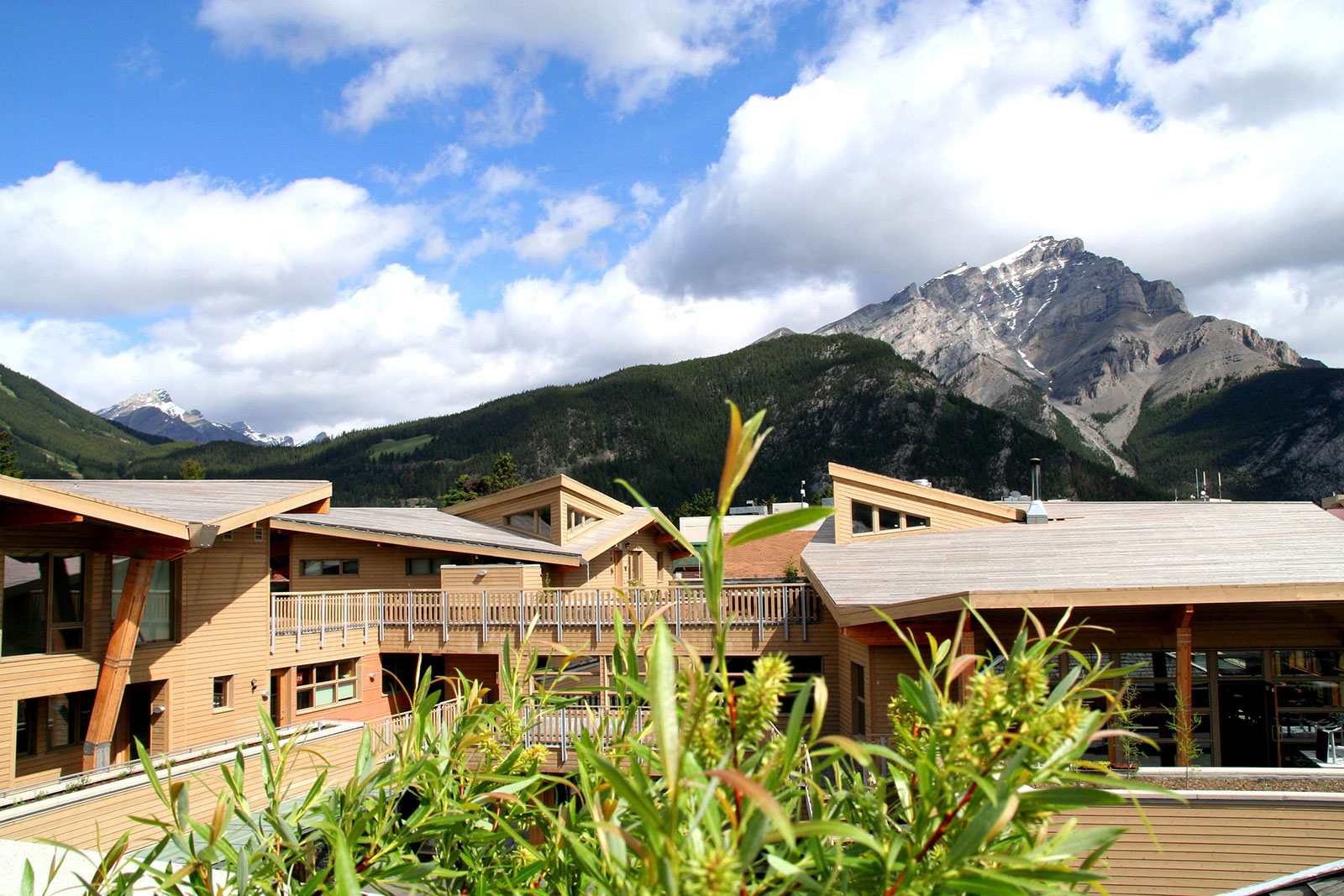 Mixed-Use Commercial and Residential Complex called Bison Courtyard at Banff with Modern Wood Picket Fence, Cool Eyebrow Windows that Frame the Rocky Mountains, Butterfly Roofs and Wood Siding by Best Virginia Architects.